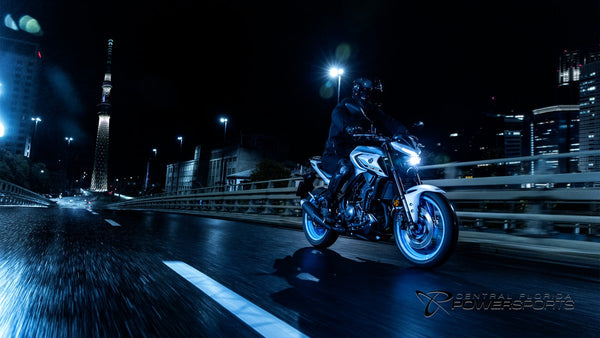 Rider on a 2026 Yamaha MT-03 crossing a city bridge at night