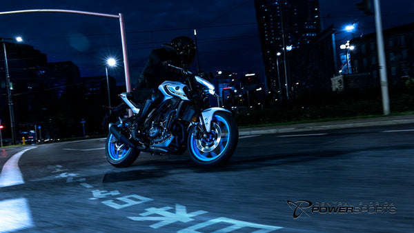 Rider on a 2026 Yamaha MT-03 moving through a city intersection at night