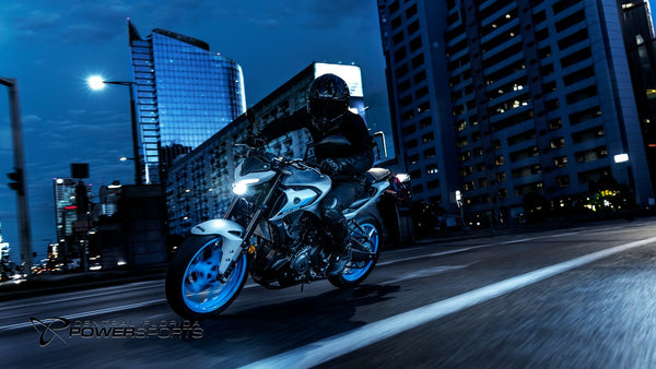 Rider leaning a 2026 Yamaha MT-03 on a city street at night