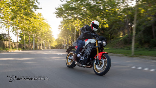 Rider leaning a 2026 Yamaha XSR900 through a tree-lined street
