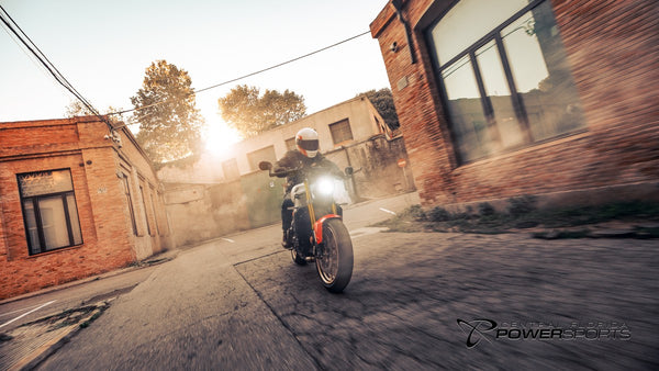 Rider on a 2026 Yamaha XSR900 passing brick buildings at sunset