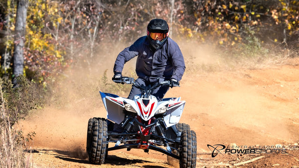 Helmeted rider approaching on a 2026 Yamaha YFZ450R SE on a dirt trail