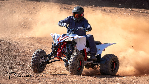 Helmeted rider turning a 2026 Yamaha YFZ450R SE on loose dirt